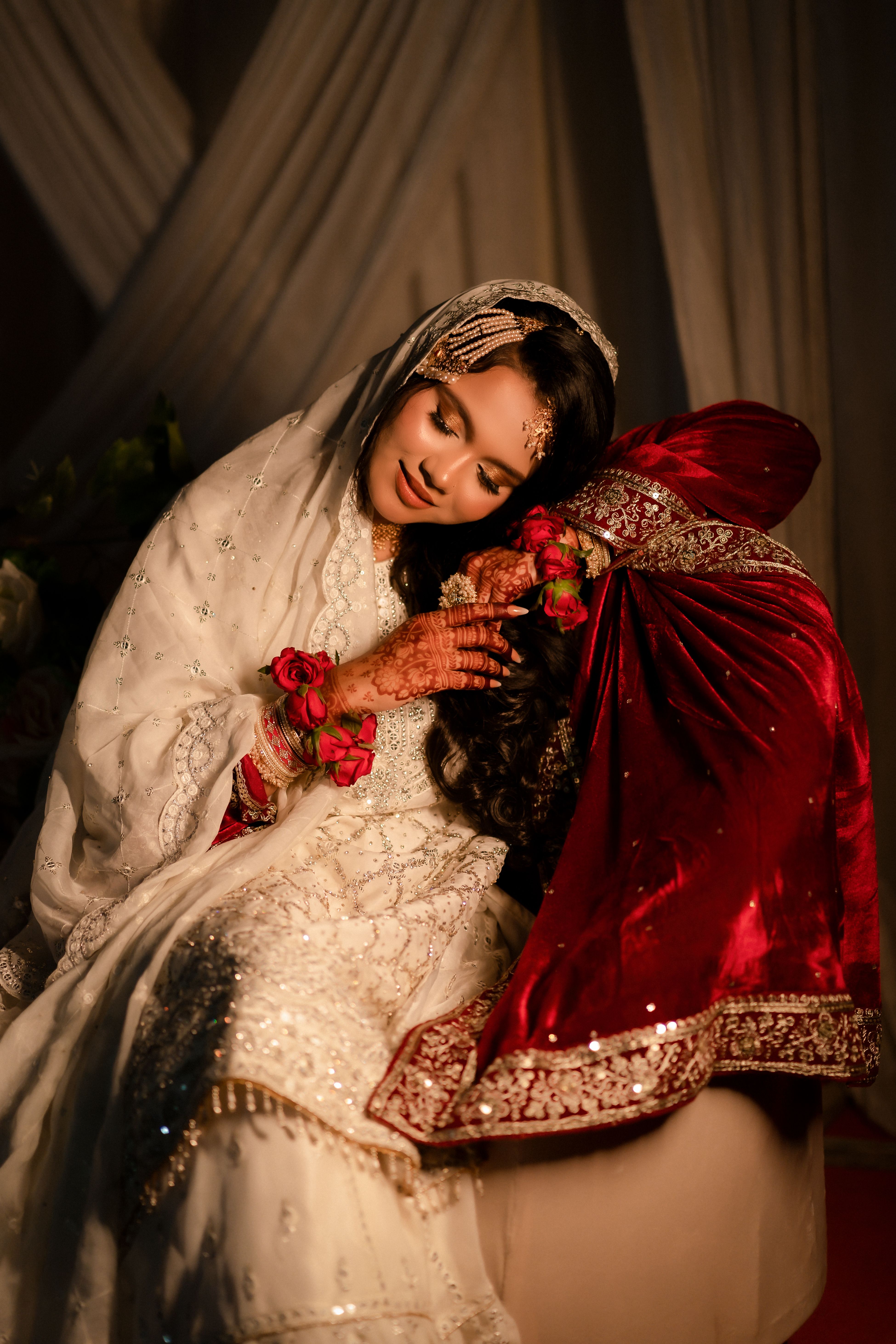 A bride in elegant Indian attire enjoying a tender moment on her special day, showcasing cultural grace and beauty.