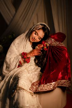 A bride in elegant Indian attire enjoying a tender moment on her special day, showcasing cultural grace and beauty.