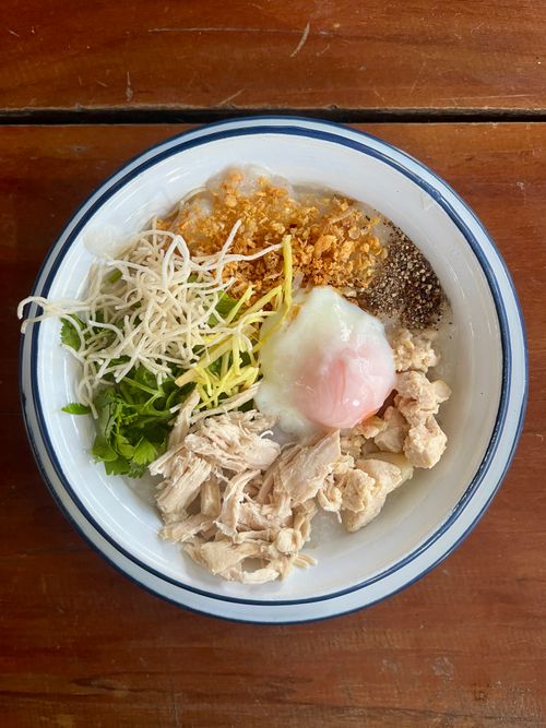 Free Top view of Thai chicken congee garnished with fresh herbs and a soft-boiled egg. Stock Photo
