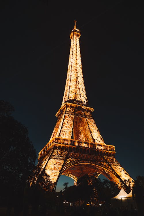Hình ảnh miễn phí đầy sống động về tháp Eiffel vào ban đêm, khi ánh đèn vàng lung linh chiếu sáng khắp nơi, mang đến cho bạn trải nghiệm tuyệt vời không đâu có thể sánh được.