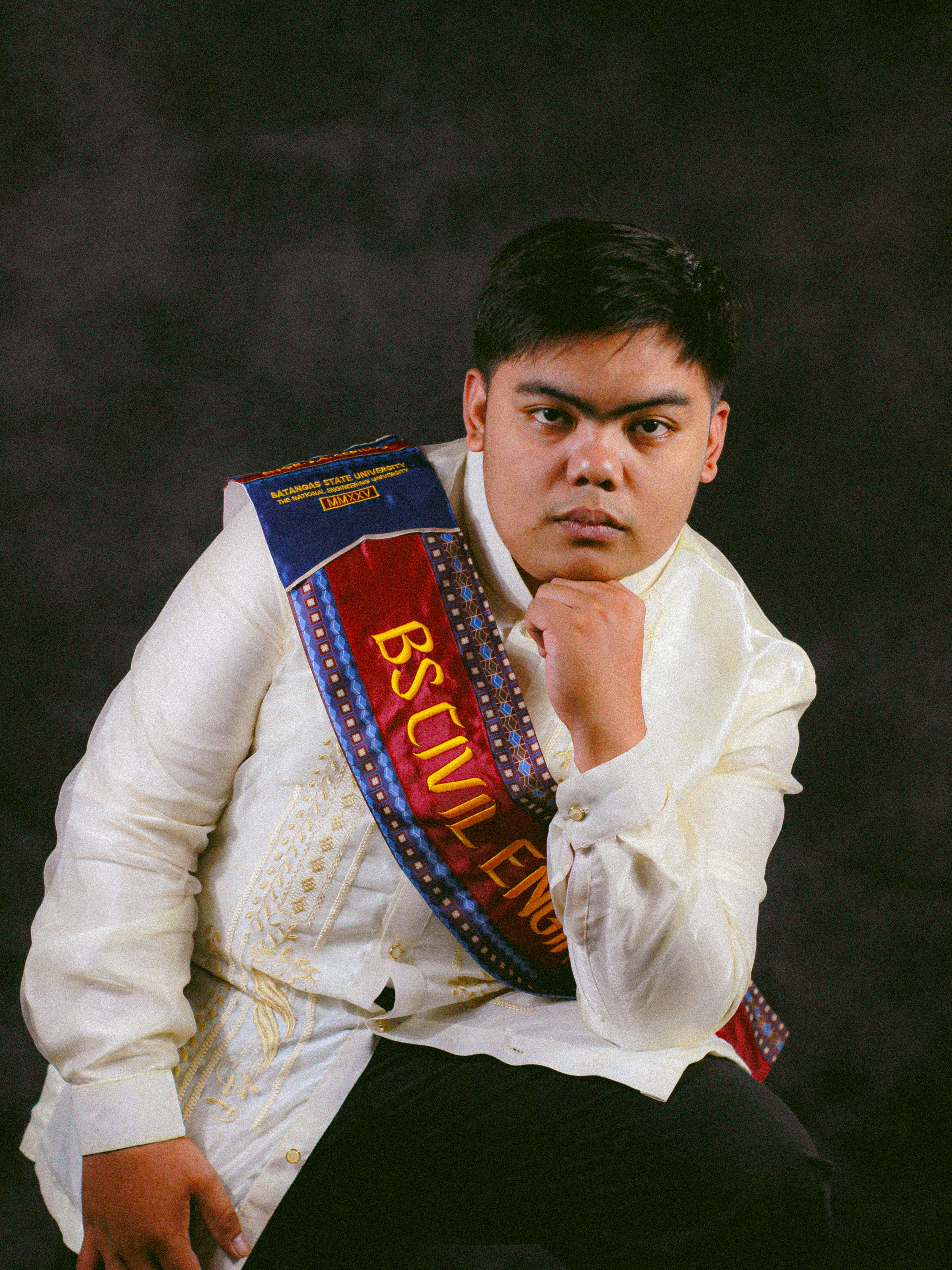 A confident civil engineering graduate in traditional attire during a portrait session.