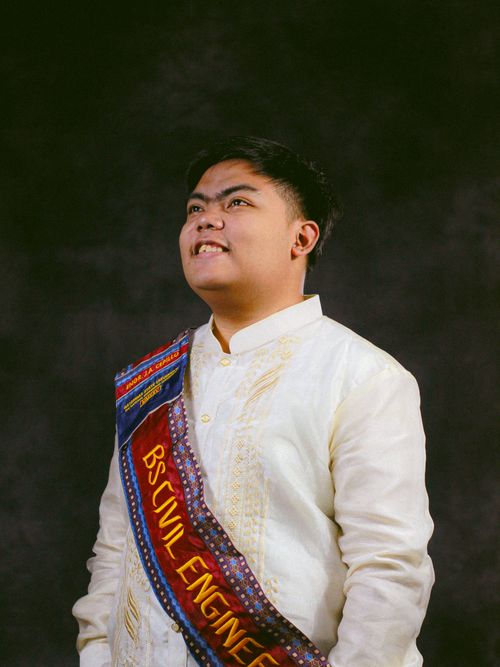 Free Portrait of a proud graduate in embroidered formal wear with a BS Civil Engineering sash. Stock Photo