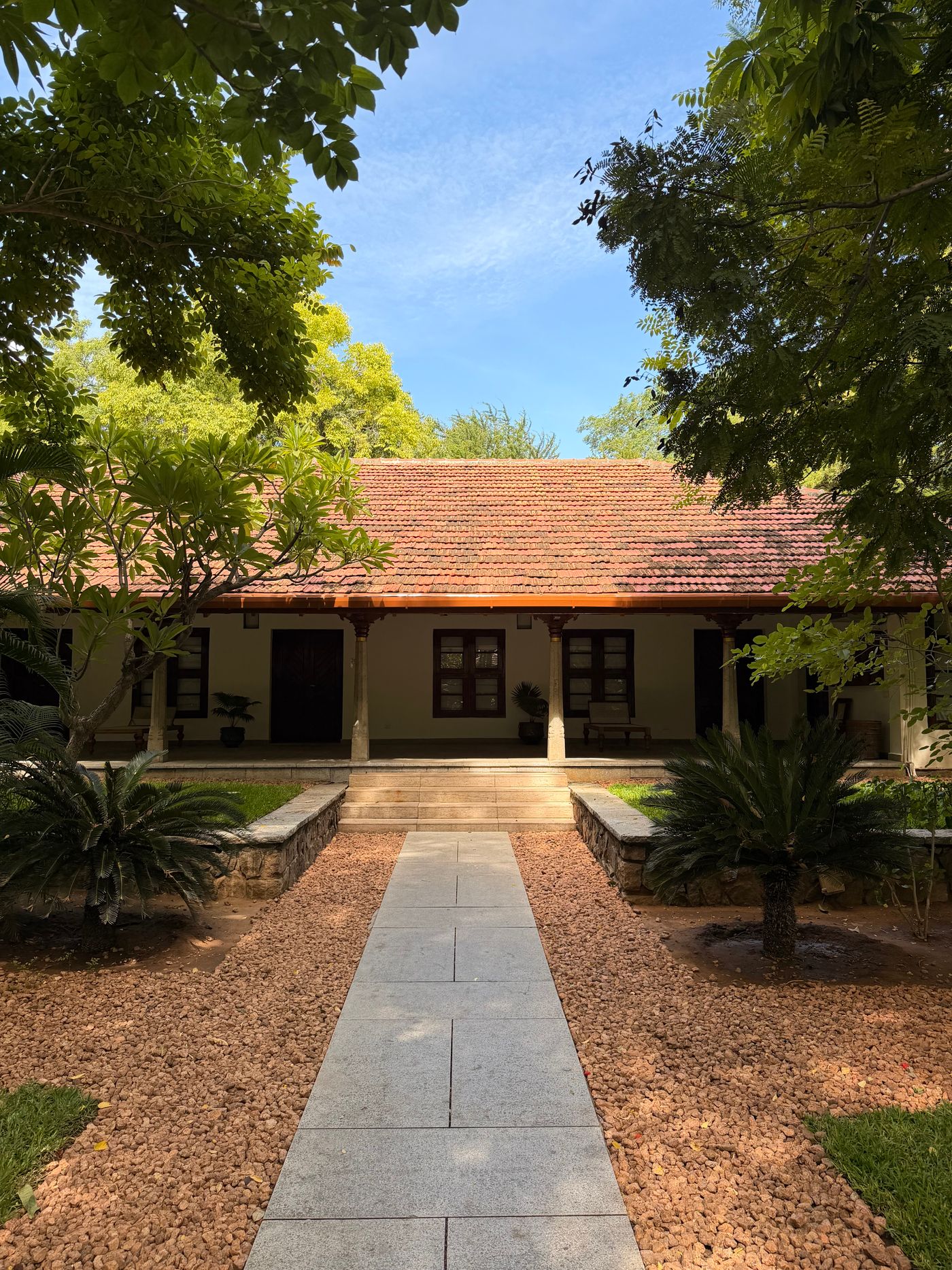 Entrance court with a gravel garden, stone path and clay-tiled roof