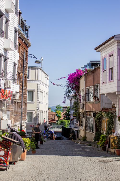 Free Picturesque Istanbul street scene with vibrant bougainvillea, charming architecture, and clear sky. Stock Photo