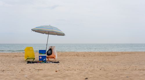 Free Serene beach setup in Valencia with chairs and umbrella by the sea, ideal for summer relaxation. Stock Photo