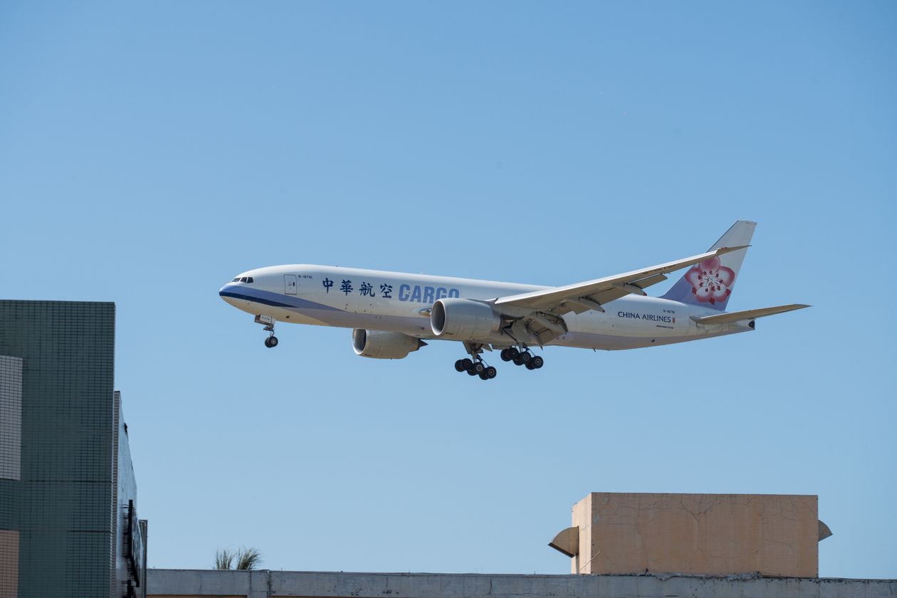 Cargo plane landing against a clear blue sky