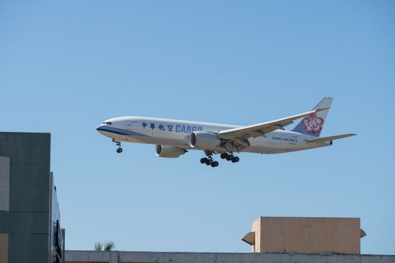 Cargo plane landing against a clear blue sky