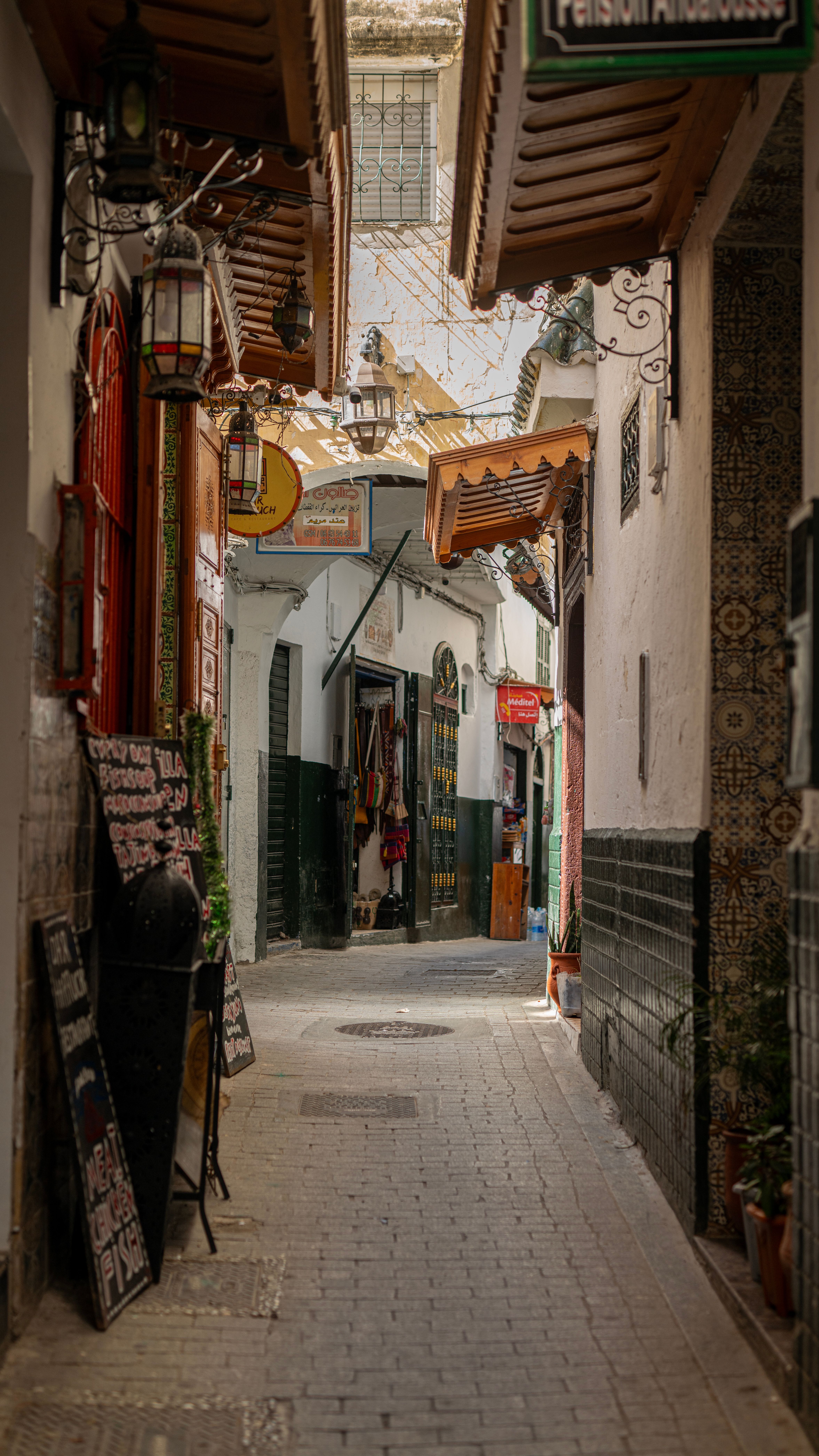 Explore a sunlit alley in Tangier's historic medina, featuring traditional Moroccan architecture.