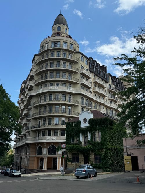 Free Stunning architecture of a historic rotunda-style building in Odessa, captured with urban greenery and cars on the street. Stock Photo