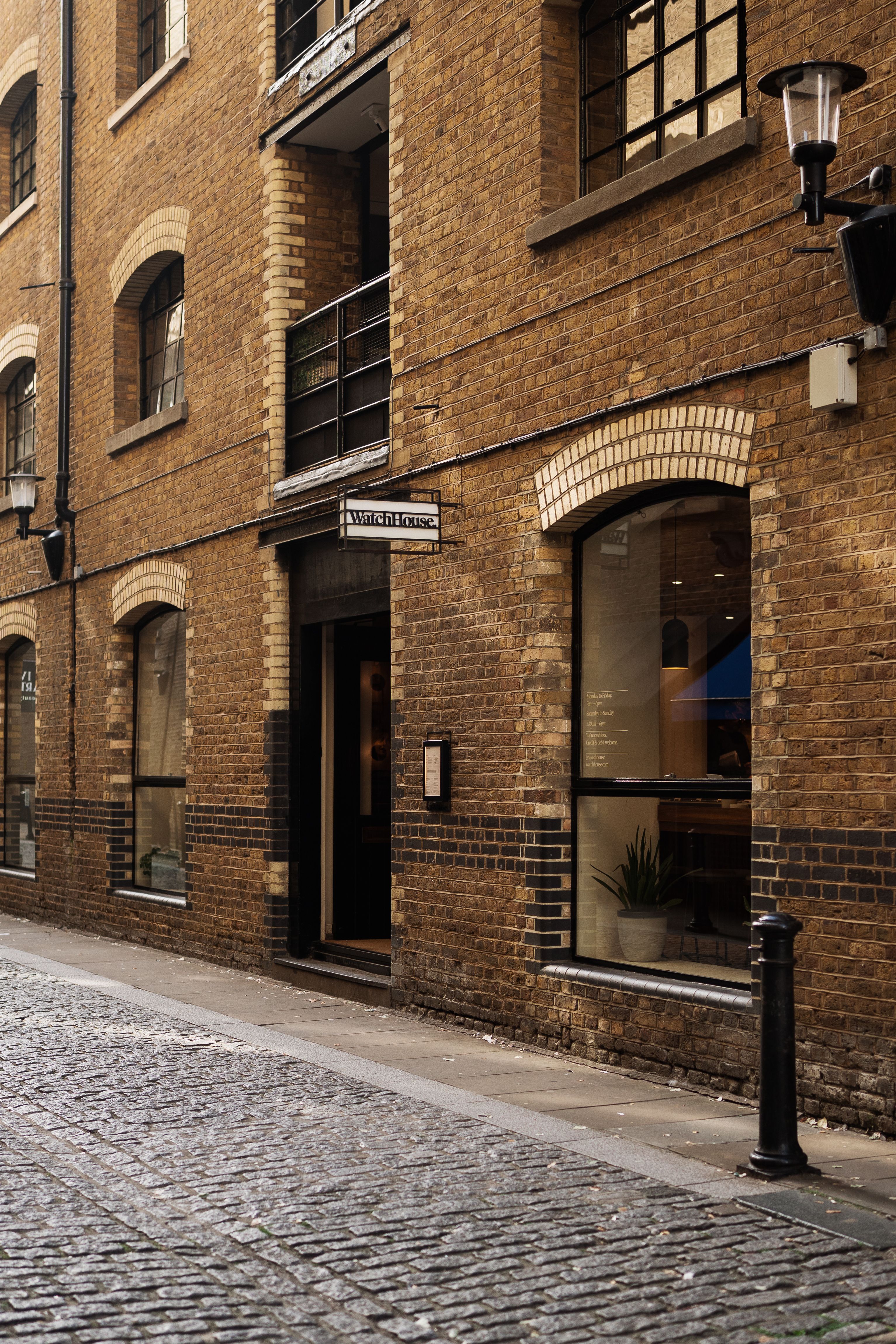 Historic brick building on cobblestone street in London.