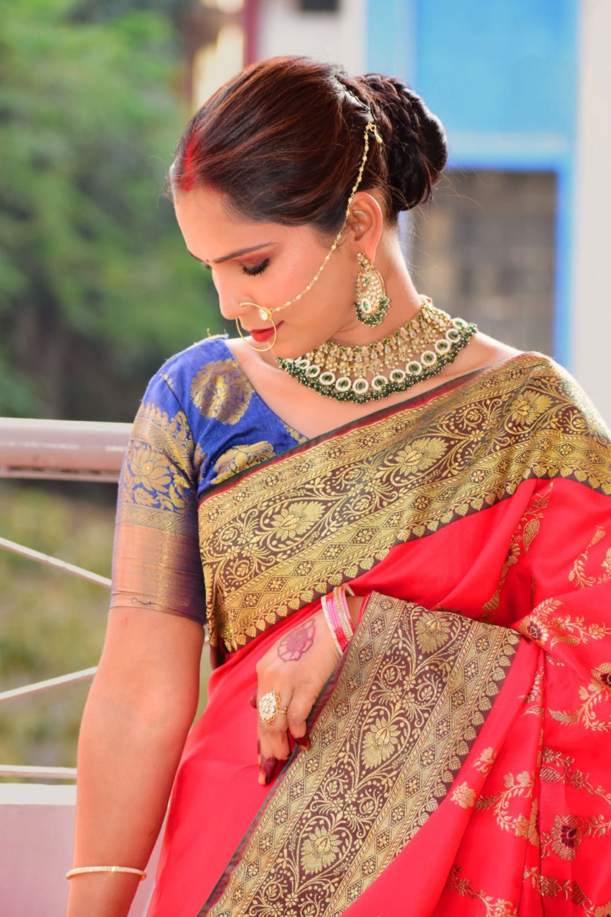 Woman in a red and gold zari saree with bridal jewellery