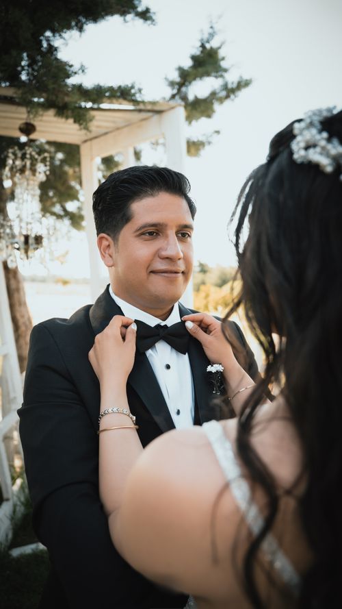 Free Bride adjusting groom's bow tie during a wedding ceremony in Ankara. Stock Photo