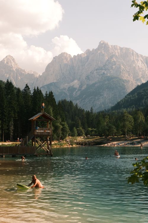 Free People enjoying a summer day at a scenic mountain lake with diving platform. Stock Photo