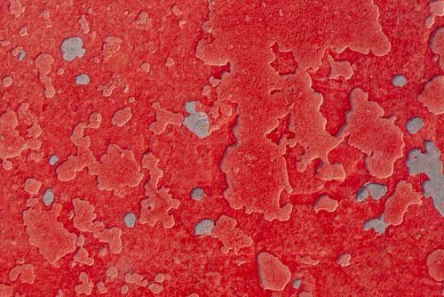 Free Abstract image of a red textured surface with chipped paint revealing gray underneath. Stock Photo