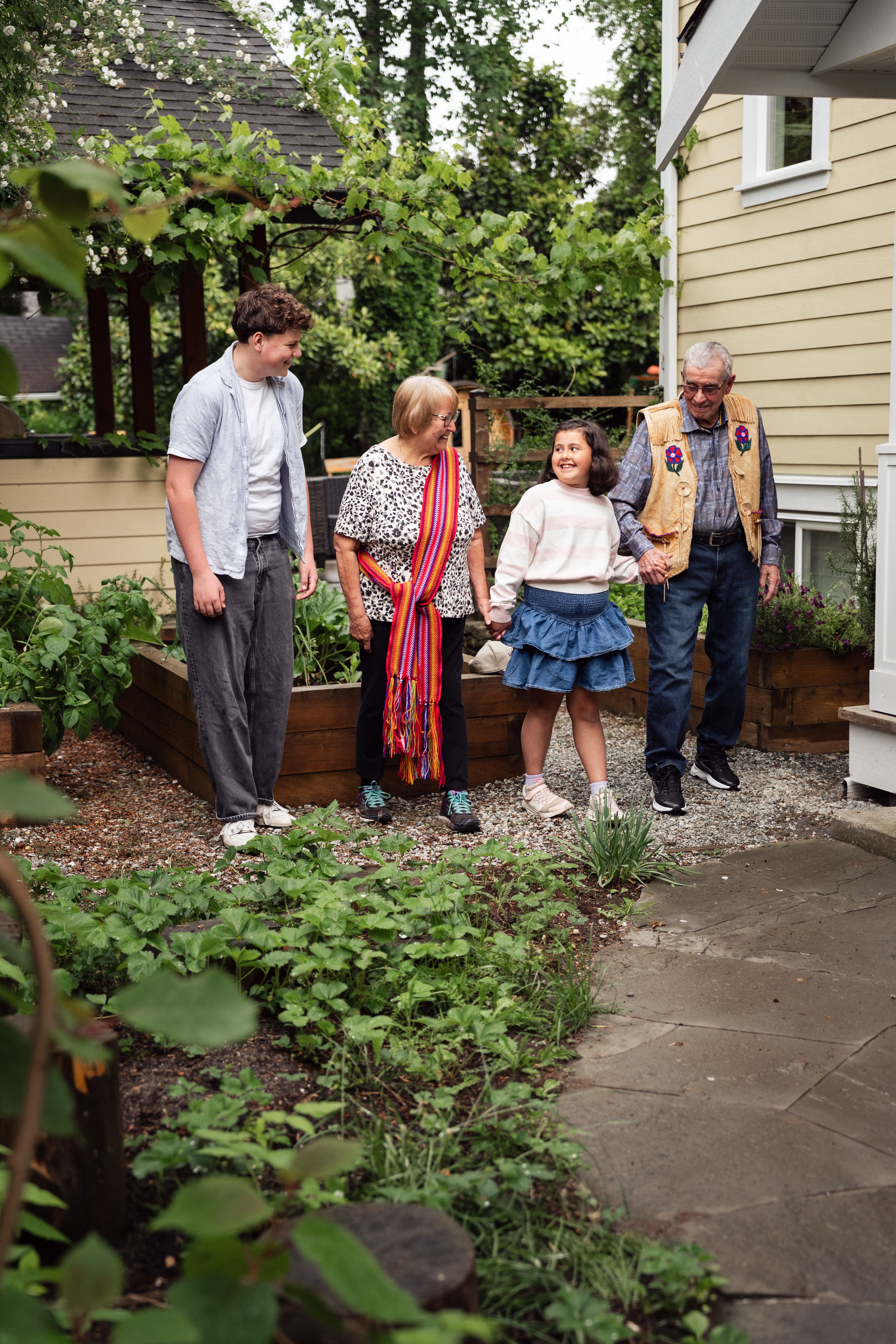 Family gathered around a table in a leafy backyard garden — photo by Jelly Marketing on Pexels