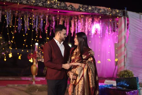 Free An elegantly dressed couple at a vibrant cultural celebration with lights and decorations. Stock Photo