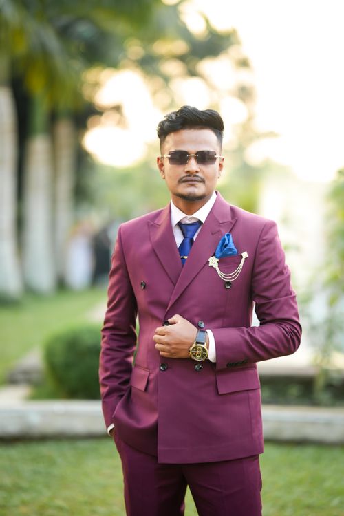 Free Confident man in a burgundy suit posing outdoors wearing sunglasses. Stock Photo
