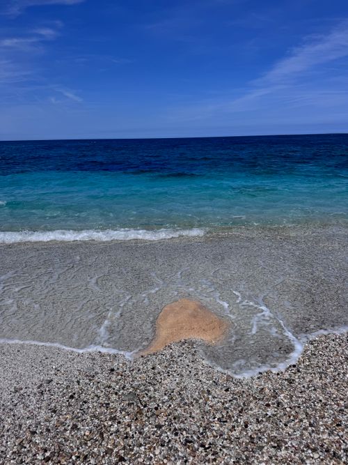 Free Crystal clear waters at a serene beach in Sardinia, Italy, during a sunny day. Stock Photo