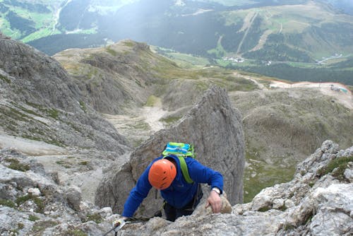 Man In Blue Jacket Rock Climbing