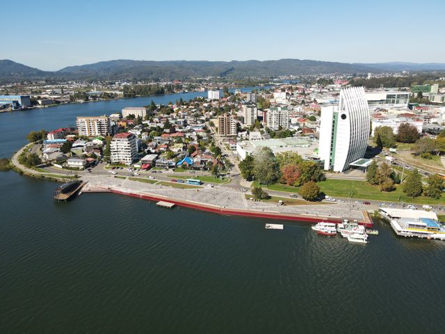 Aerial photo of Valdivia's waterfront showcasing buildings, rivers, and landscapes.