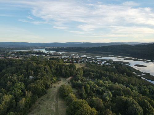 Free Scenic aerial view of river, forest, and village near Valdivia, Chile, under a beautiful sky. Stock Photo