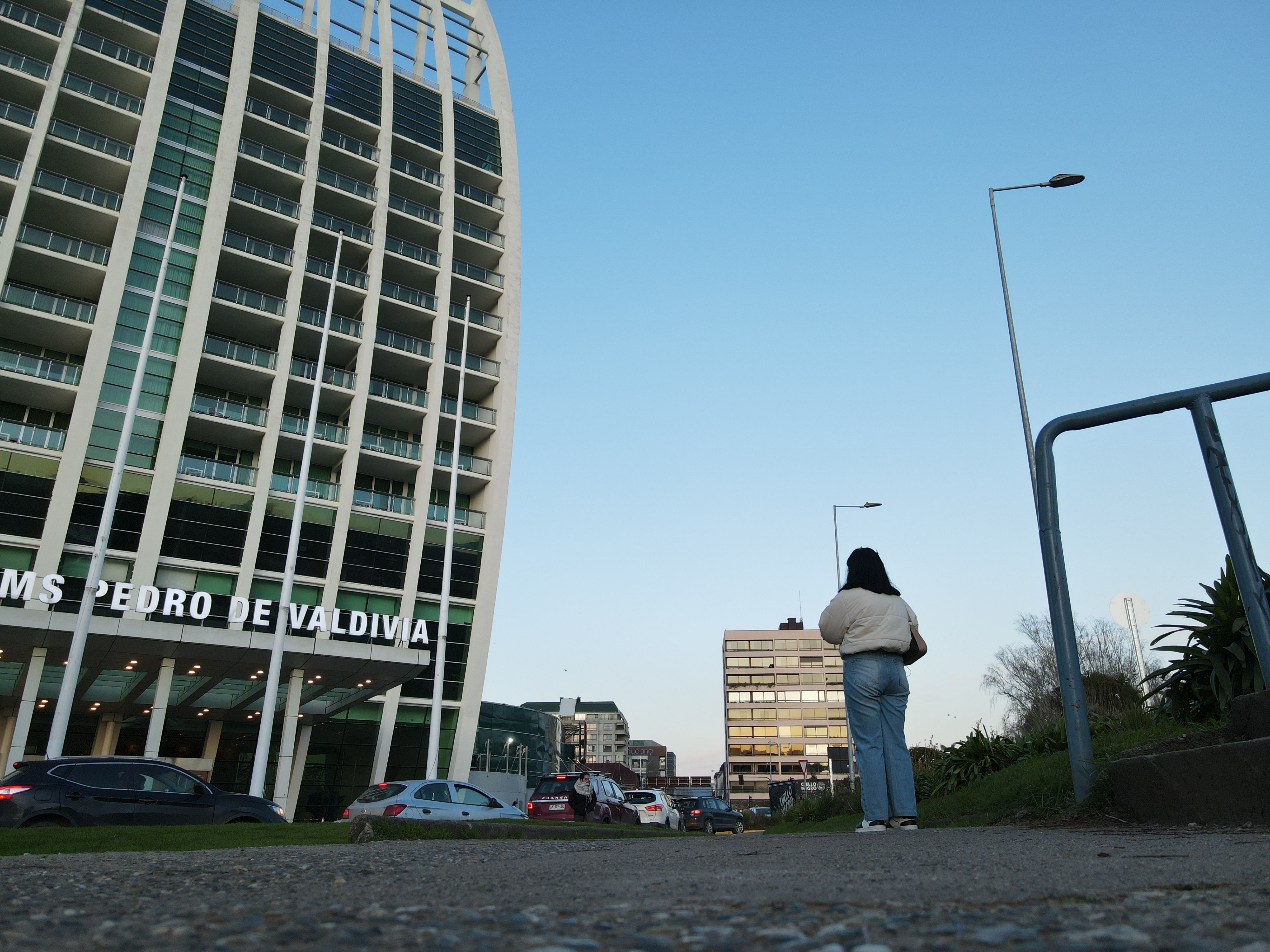 A person walking near Hotel Dreams Pedro de Valdivia in an urban setting in Valdivia, Chile.