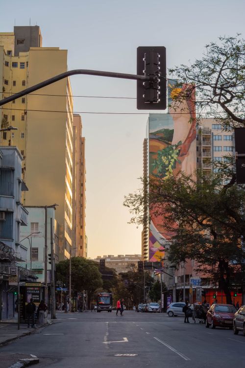 Free Vibrant city street in Belo Horizonte with mural and streetlights during sunset. Stock Photo
