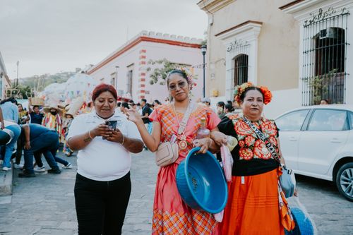 Free Women in traditional Oaxacan attire enjoy a lively street festival celebration. Stock Photo