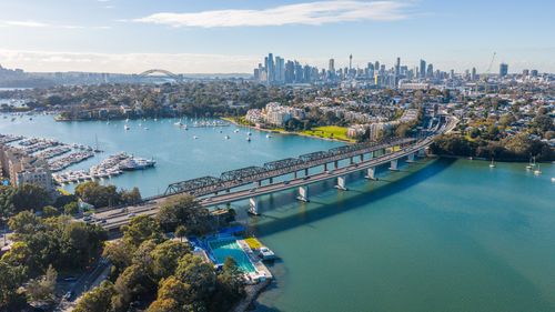 Free A stunning aerial photograph capturing the Sydney skyline, including the iconic Harbour Bridge and surrounding waters. Stock Photo