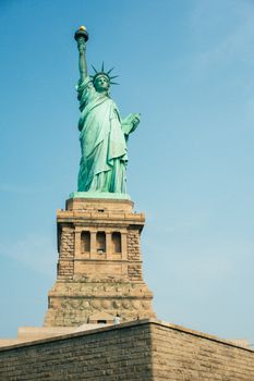Iconic view of the Statue of Liberty in New York City under a bright blue sky.