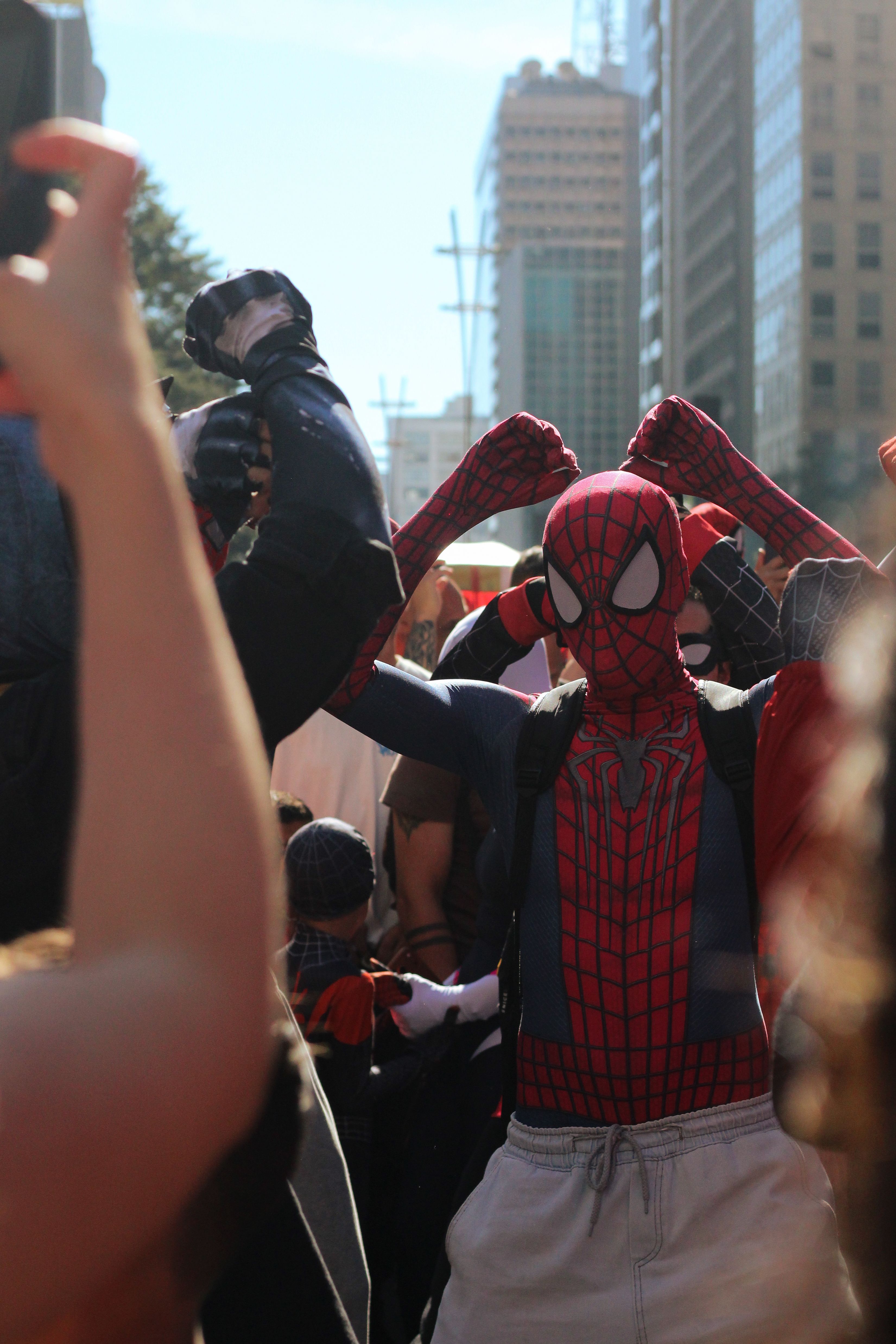 Dynamic cosplay gathering in São Paulo with a Spider-Man theme in an urban setting.