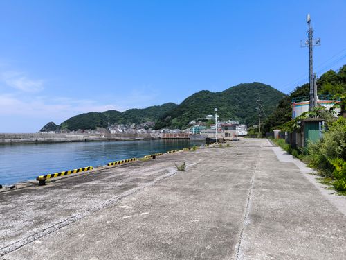 Free A serene summer view of a coastal port with lush green hills and clear blue skies in Ōita Prefecture, Japan. Stock Photo