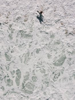 Drone captures surfer navigating waves off Rio de Janeiro's coast.