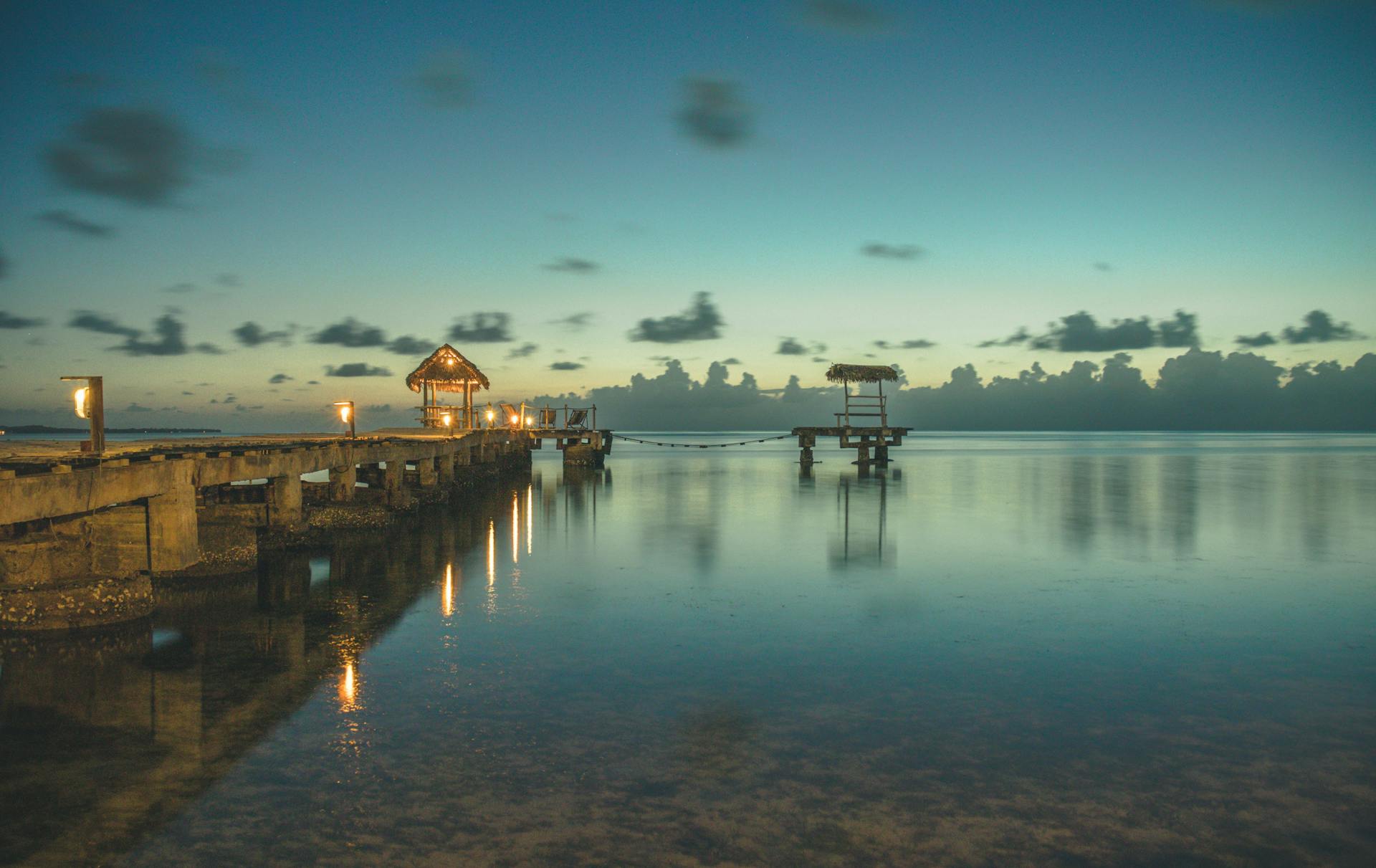 Serene view of a wooden dock at sunrise over calm waters in Toamasina Province, Madagascar.