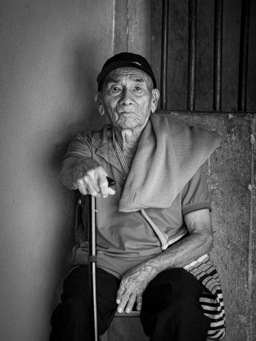 Free Black and white portrait of a senior man seated indoors, conveying wisdom and resilience. Stock Photo