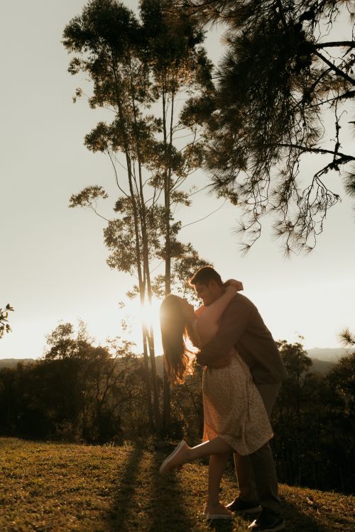 Free Couple sharing a tender moment at sunset surrounded by nature. Stock Photo