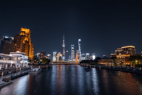 Free A stunning night view of Shanghai's illuminated skyline reflecting on the Huangpu River. Stock Photo