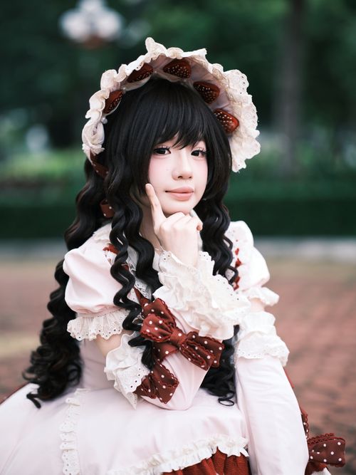 Free Beautiful young woman in Lolita fashion posing outdoors with a thoughtful expression. Stock Photo