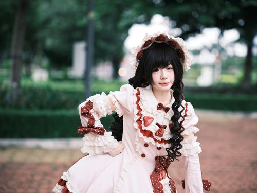 Free A young woman wearing elegant Lolita fashion poses in a lush garden. Stock Photo