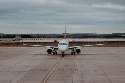Free A commercial airplane taxiing on the runway at Roissy-en-France, under a cloudy sky. Stock Photo