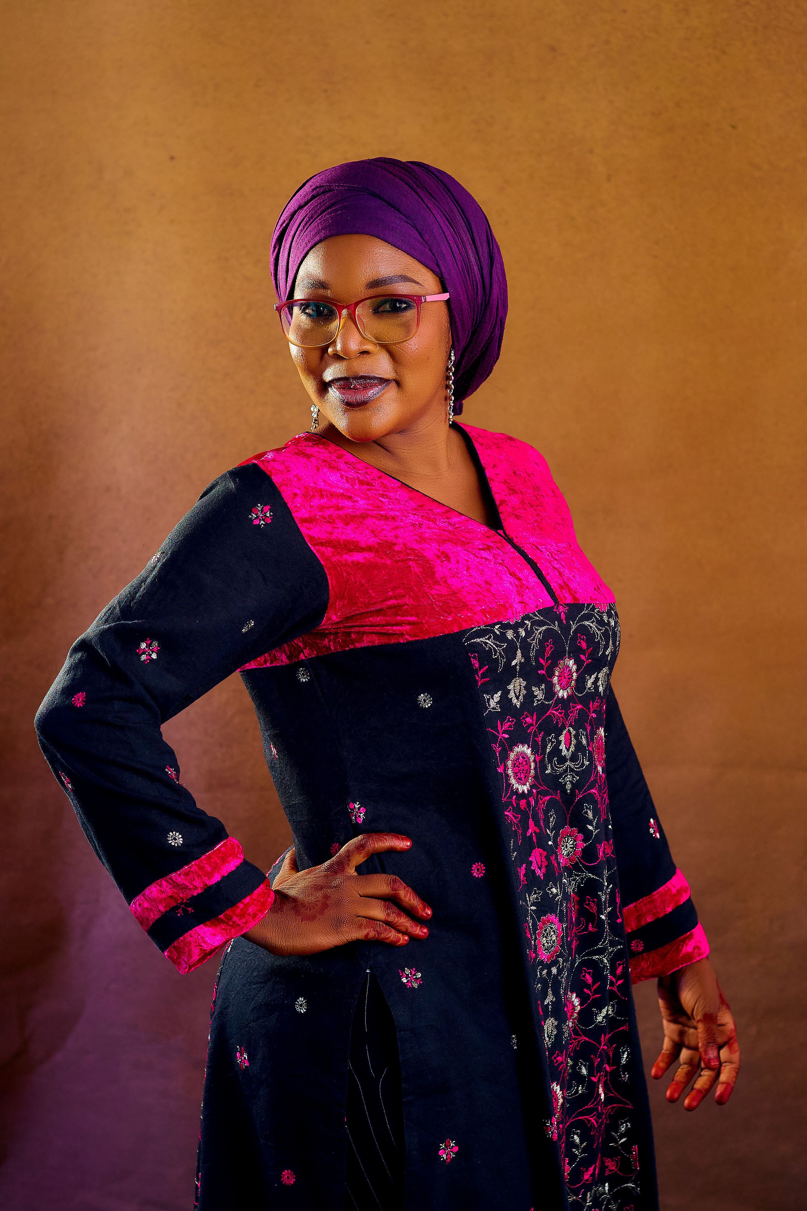 Portrait of an adult woman in vibrant traditional clothing with a confident pose.