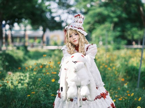 Free A fantasy character in an ornate costume stands in a vibrant outdoor setting, exuding whimsy and mystery. Stock Photo
