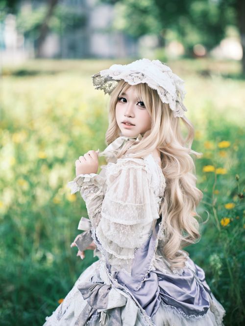 Free Woman in Victorian dress with bonnet in a summer meadow. Stock Photo