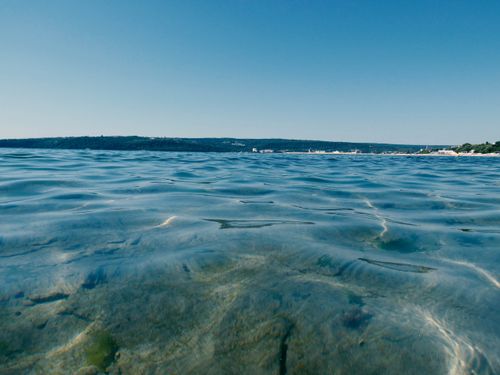 Free Serene view of clear ocean water with distant horizon under a bright blue sky. Stock Photo