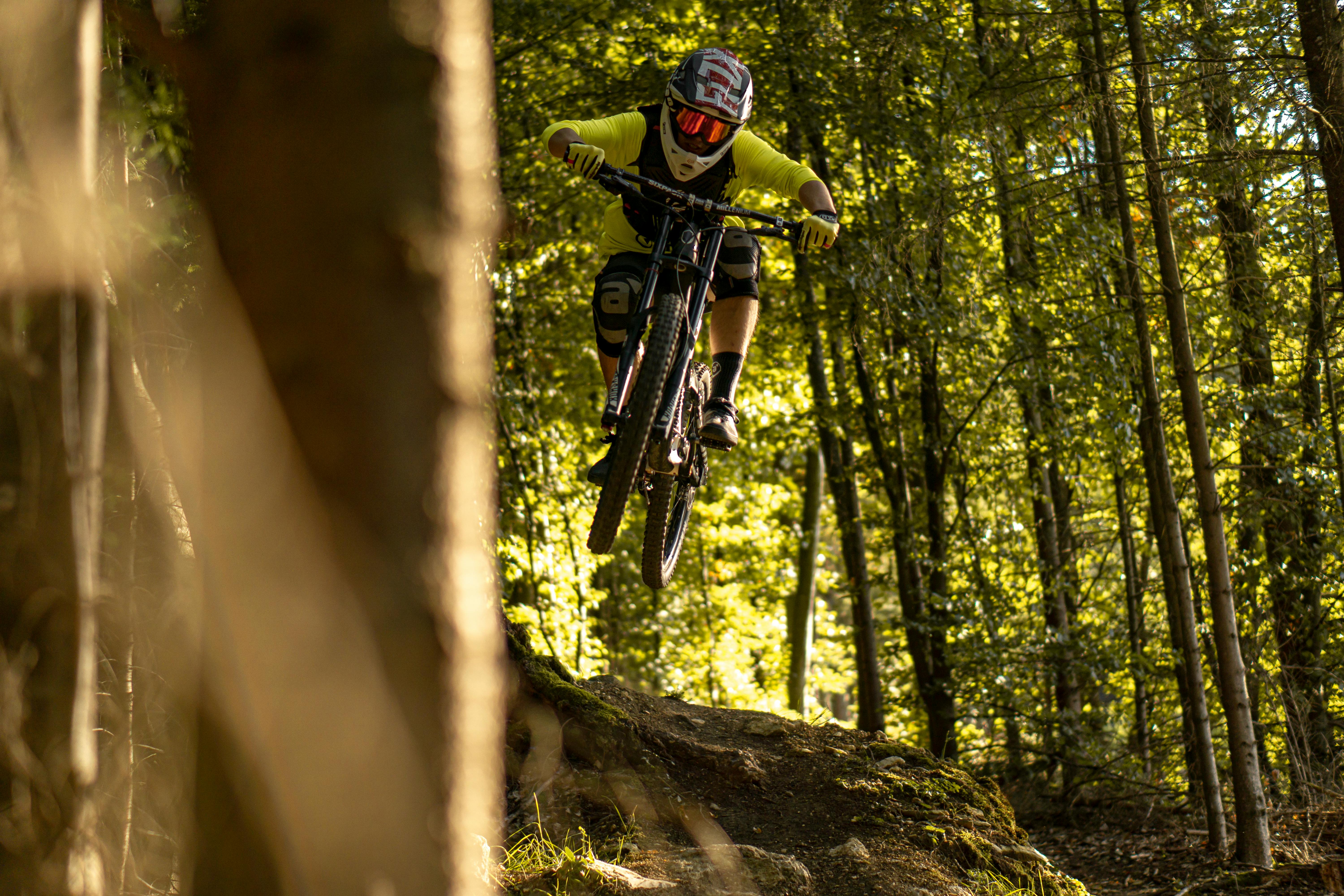 Dynamic shot of a mountain biker jumping on a forest trail in Heidenheim an der Brenz, Germany.