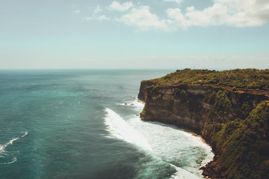 Explore the breathtaking coastal cliffs of Bali with waves crashing against the rocky shore.