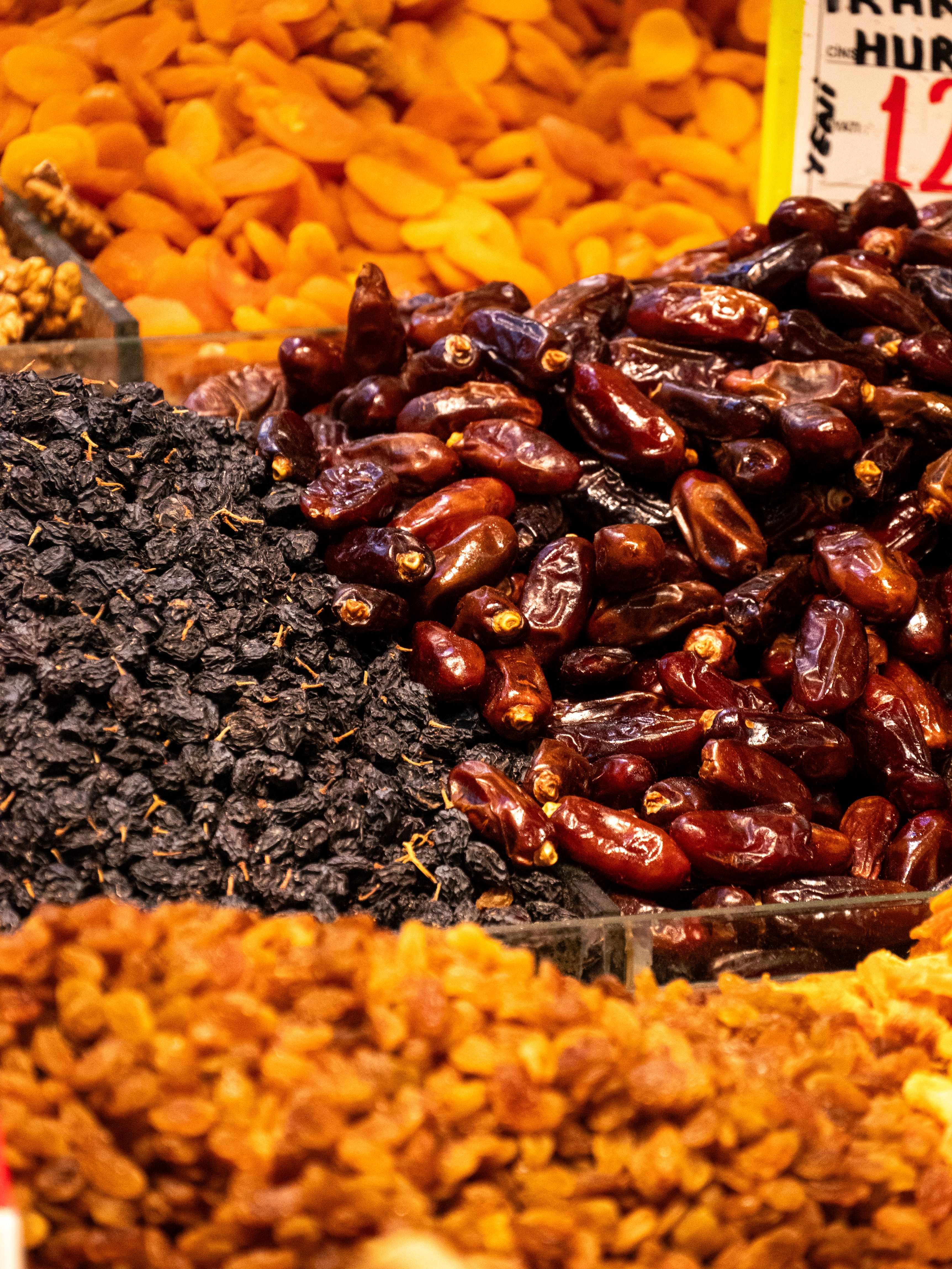A colorful display of assorted dried fruits including dates, apricots, and raisins in a market setting. - The Role of Dry Fruits in a Balanced Diet