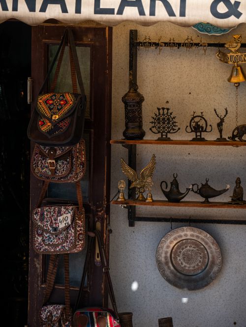 Free Charming rustic store display featuring vintage bags and decorative artifacts in warm lighting. Stock Photo