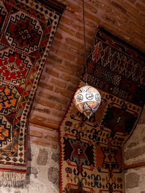 Free Cozy indoor scene showcasing traditional Turkish rugs and a vintage hanging lamp, highlighting intricate patterns and warm tones. Stock Photo