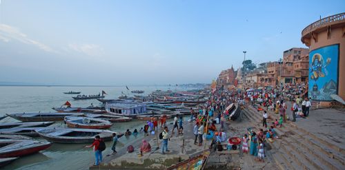 Free Colorful boats and bustling crowds along the Ganges River in Varanasi, India. Stock Photo